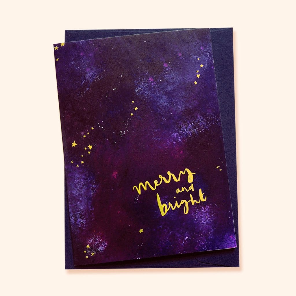 Purple Galaxy Christmas Card With The Words Merry An Bright In Gold With A Deep Navy Envelope - Annie Dornan Smith