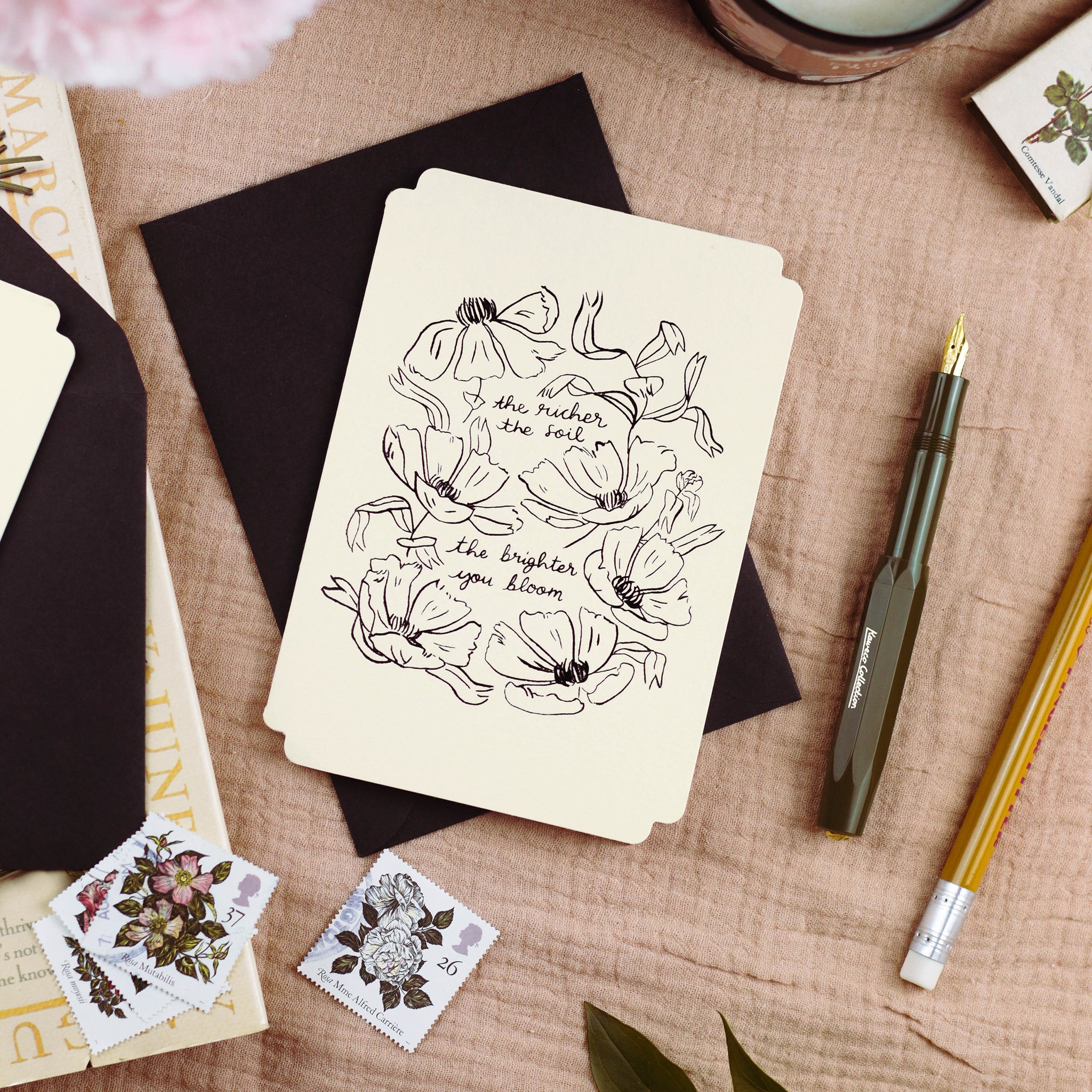 a floral design, die-cut card reads "the richer the soil, the brighter you bloom".  - Annie Dornan Smith