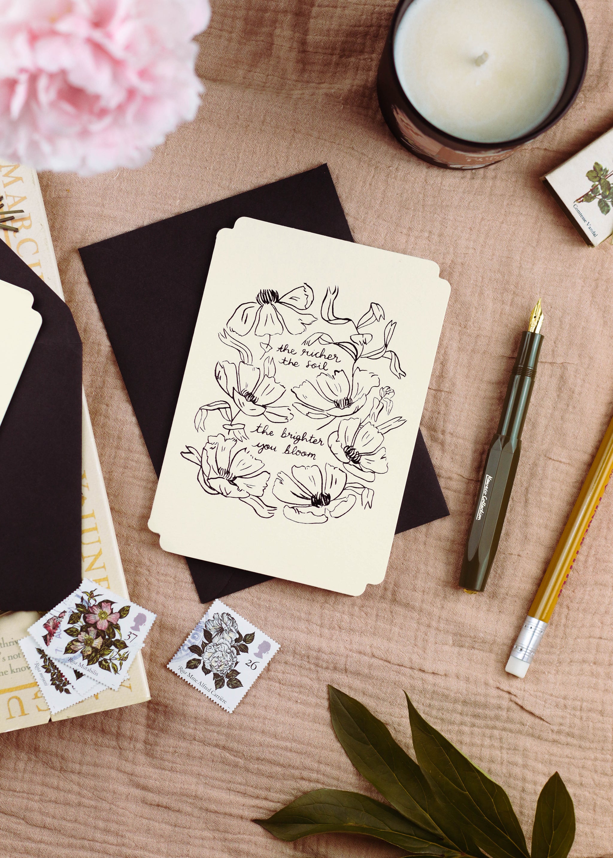 a floral design, die-cut card reads "the richer the soil, the brighter you bloom". - Annie Dornan Smith