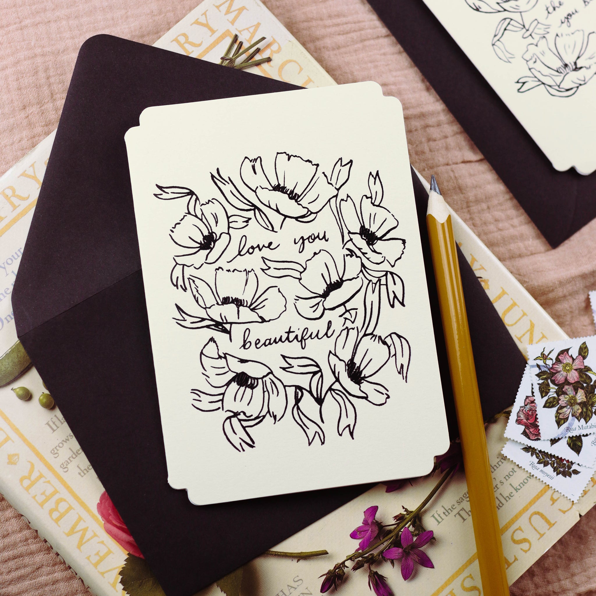 A cream, die-cut valentines card with black, foiled, linework-style flower illustrations - Annie Dornan Smith