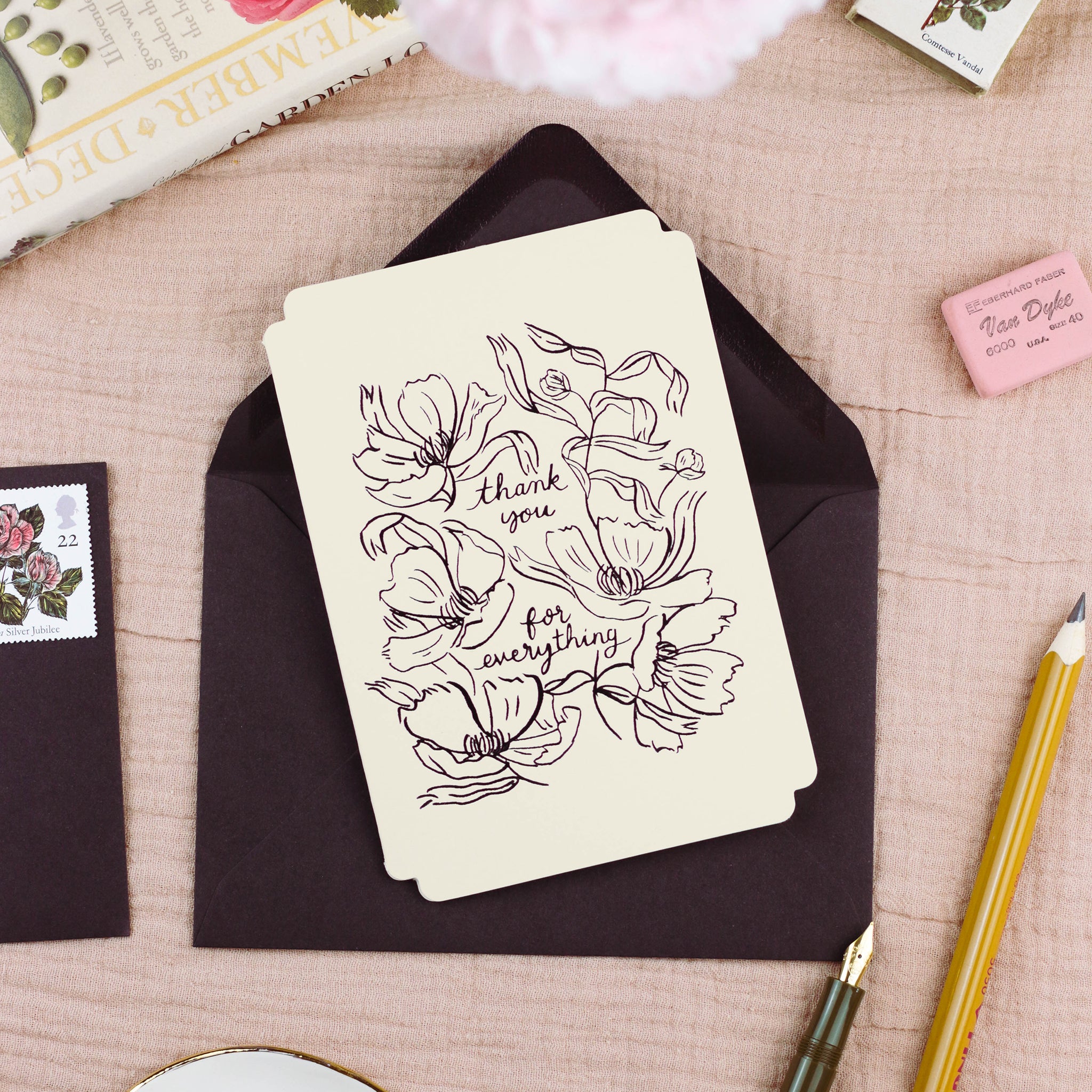 A cream, die-cut card with black foil embossed design reads "thank you for everything" surrounded by linework-style flowers.