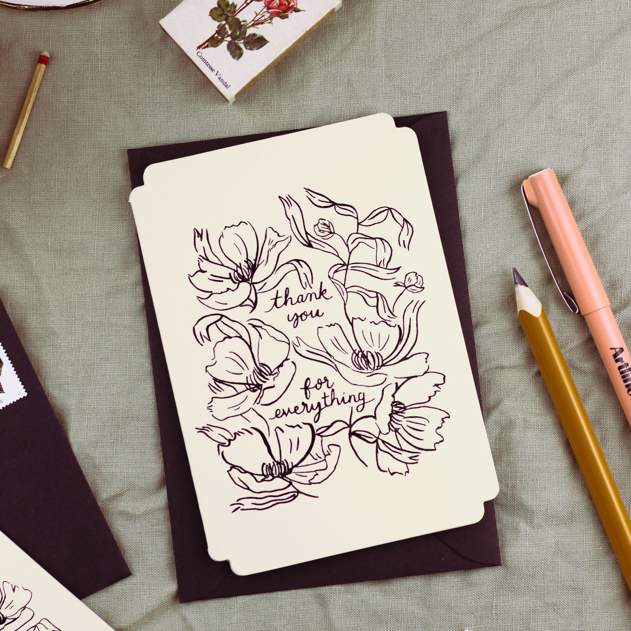 A floral-design thank you card "reads thank you for everything" in stamped black foil. It is die-cut in a vintage-inspored shape. - Annie Dornan Smith