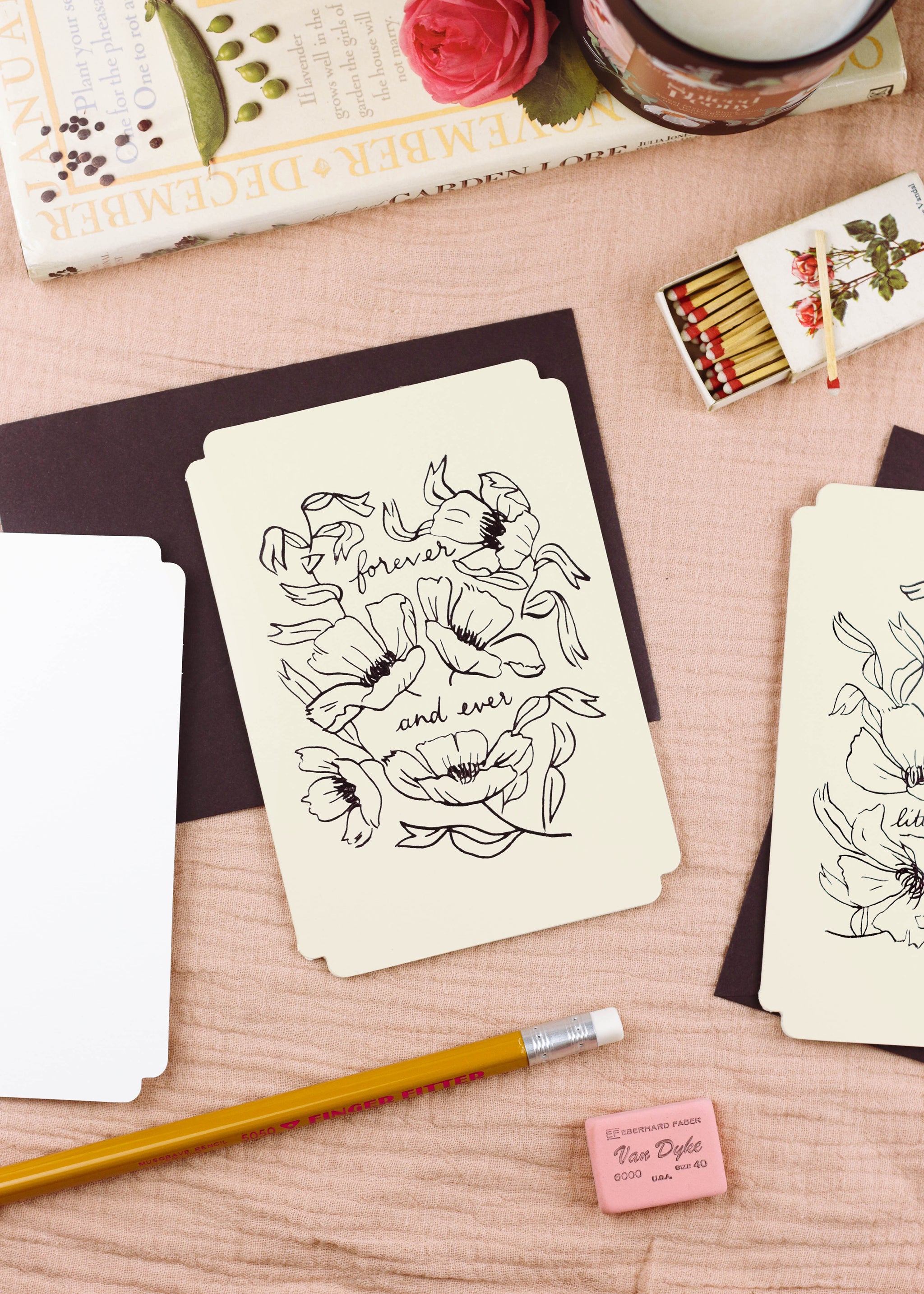 A floral wedding anniversary card in pale cream, die-cut in a vintage inspired shape. A floral linework design and lettering is stamped on the front in black foil, reading "forever and ever". - Annie Dornan Smith