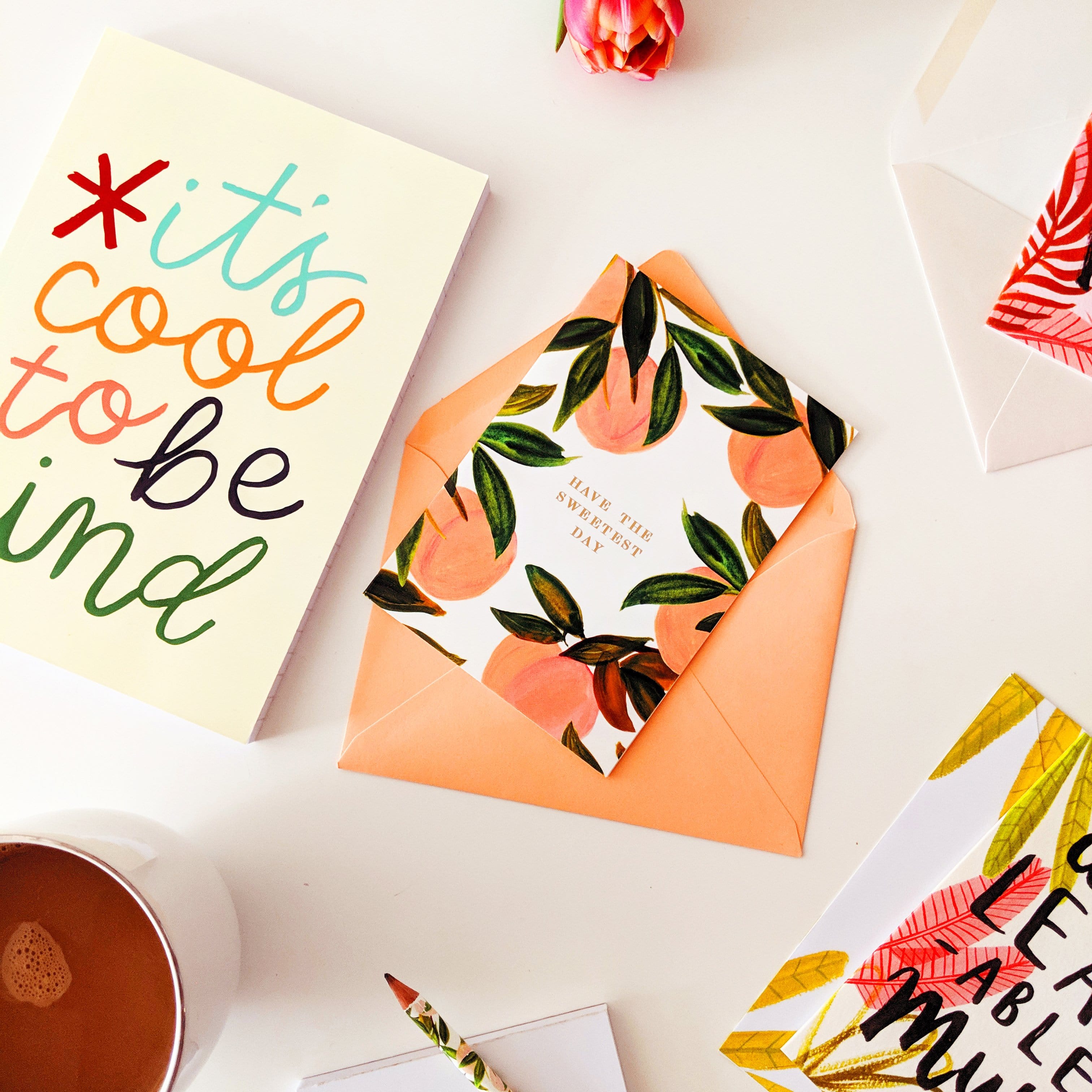 Illustrated Peach A6 Card With Have The Sweetest Day In Gold On A Table With Other Prints - Annie Dornan Smith