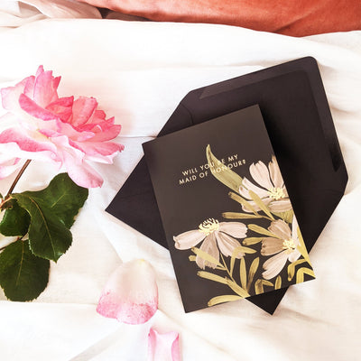 A Floral A6 Card With White And Green Flowers With Will You Be My Maid Of Honour In Gold Lettering  With Black Envelope - Annie Dornan Smith