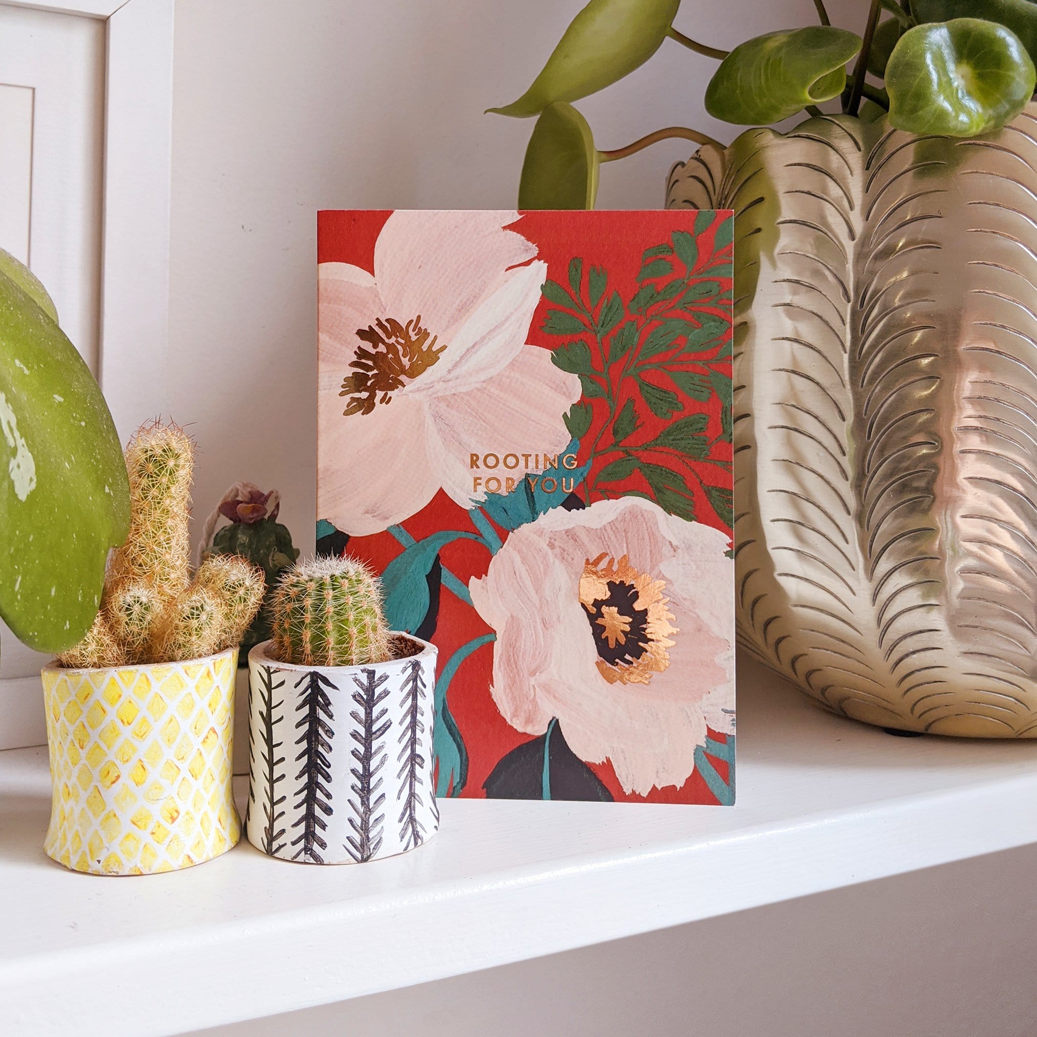 A Floral A6 Card with Pastel Pink Green And Gold Flowers With Rooting For You In Gold Lettering With Black Envelope On A Shelf - Annie Dornan Smith