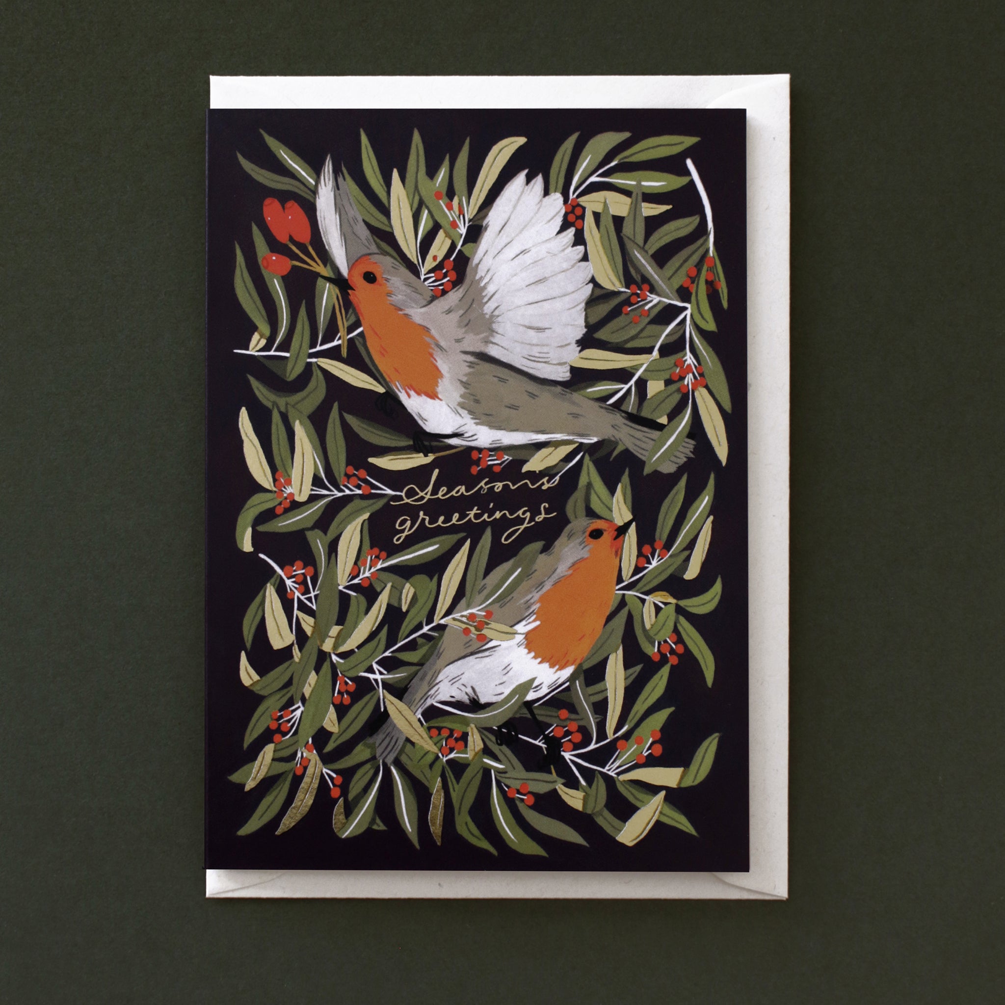 A lovely, navy blue Christmas card featuring two illustrated robins, finished with gold foil details. It comes paired with a recycled cream envelope.