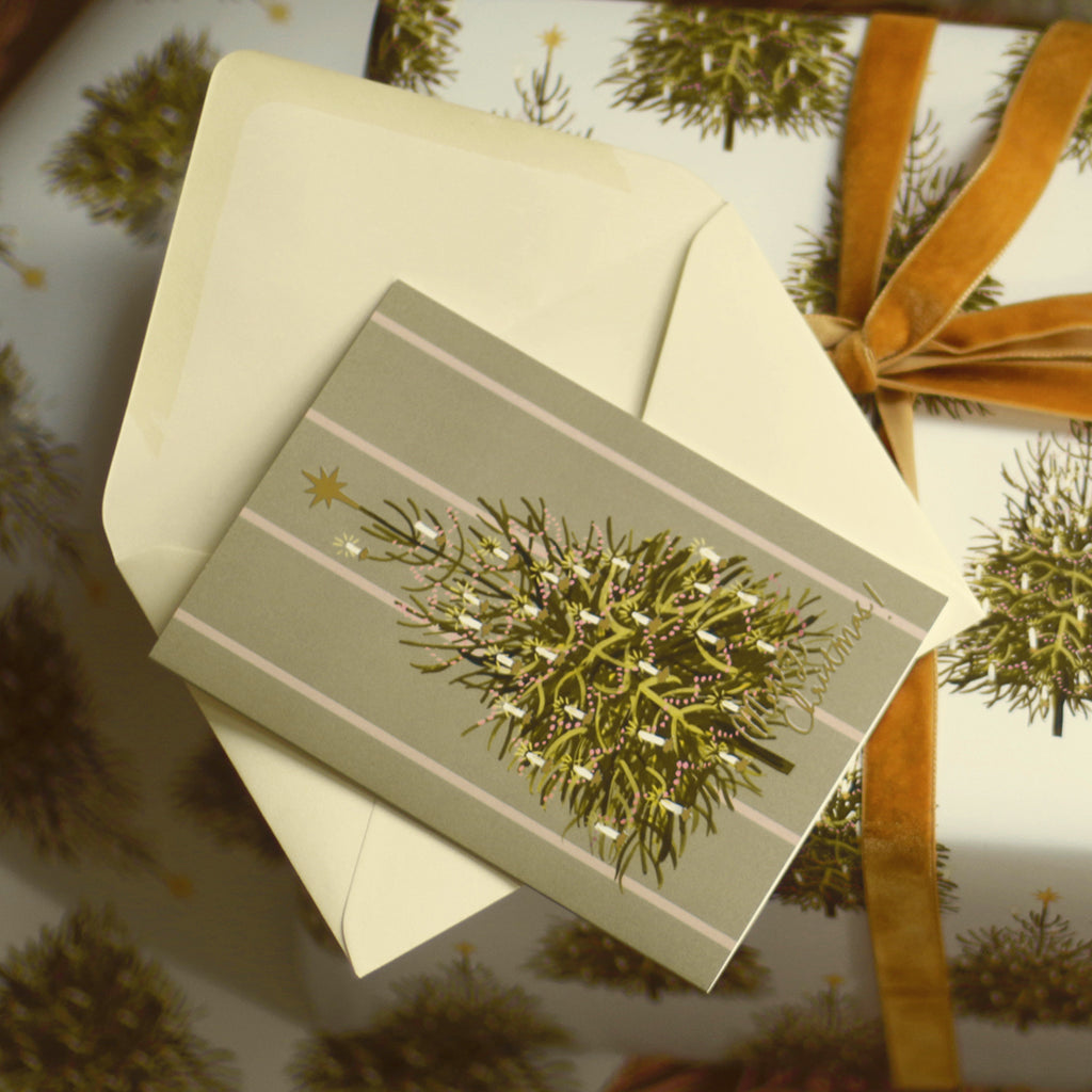 an illustrated christmas tree card with a cream envelope