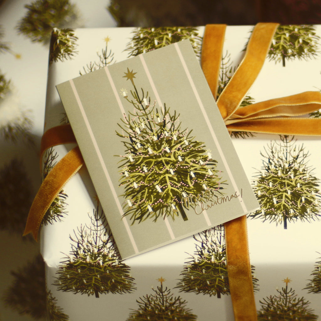 an illustrated christmas tree card with matching wrapping paper