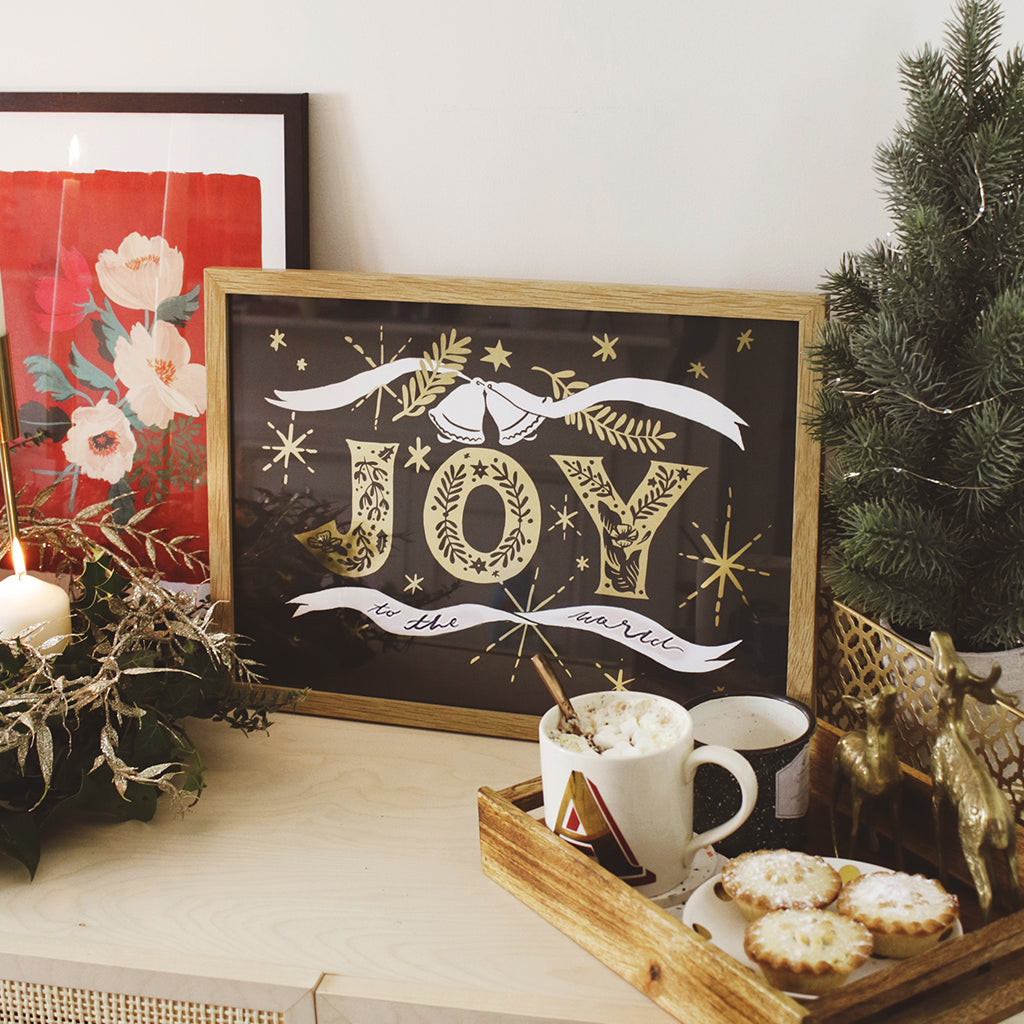 Navy Christmas Print With Gold Joy Lettering And Stars In An Oak Frame With Tray Of Mince Pies And Hot Chocolate - Annie Dornan Smith