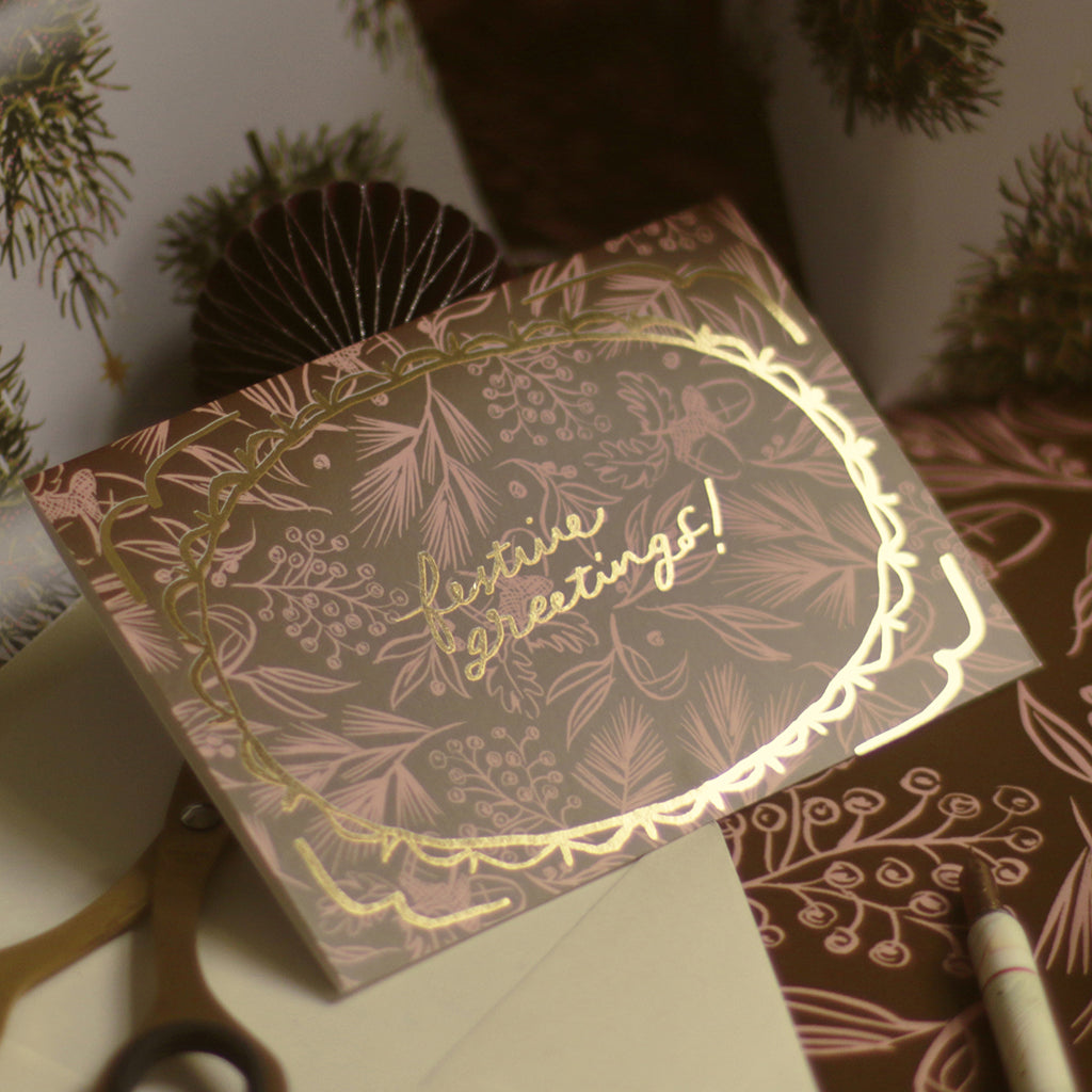 a luxe gold foiled christmas card with a pink and brown festive pattern
