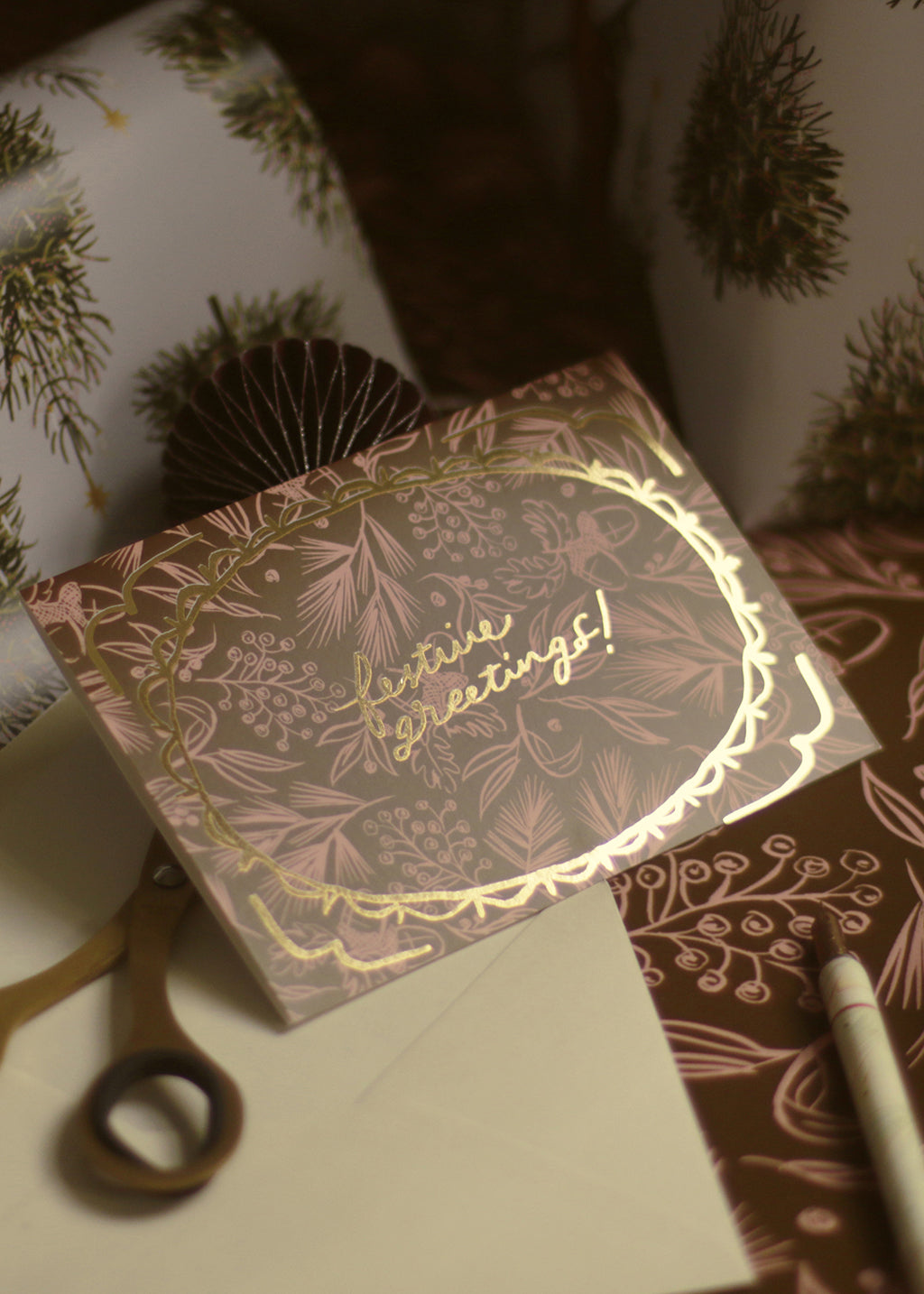 a luxe gold foiled christmas card with a pink and brown festive pattern