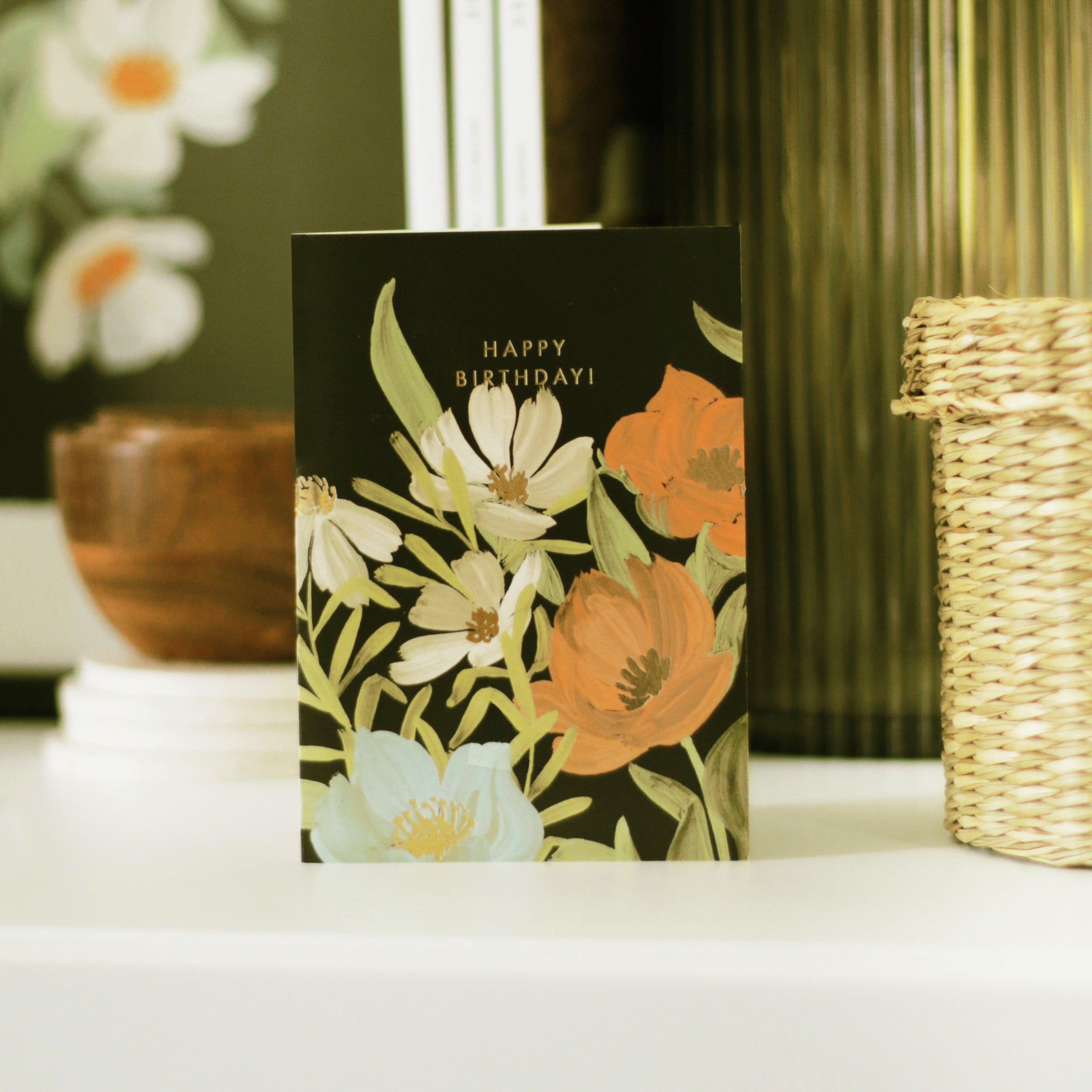 Illustrated Black Floral Card With White Orange And Blue Flowers And Gold Happy Birthday Lettering - Annie Dornan Smith