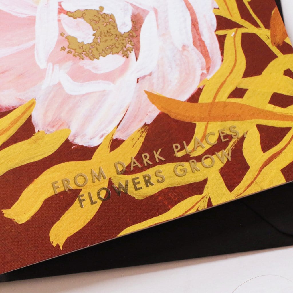 Close Up Of Botanical Greeting Card Pink English Tea Roses On Warm Brown Background With The Words From Dark Places Flowers Grow In Gold With Black Envelope - Annie Dornan Smith