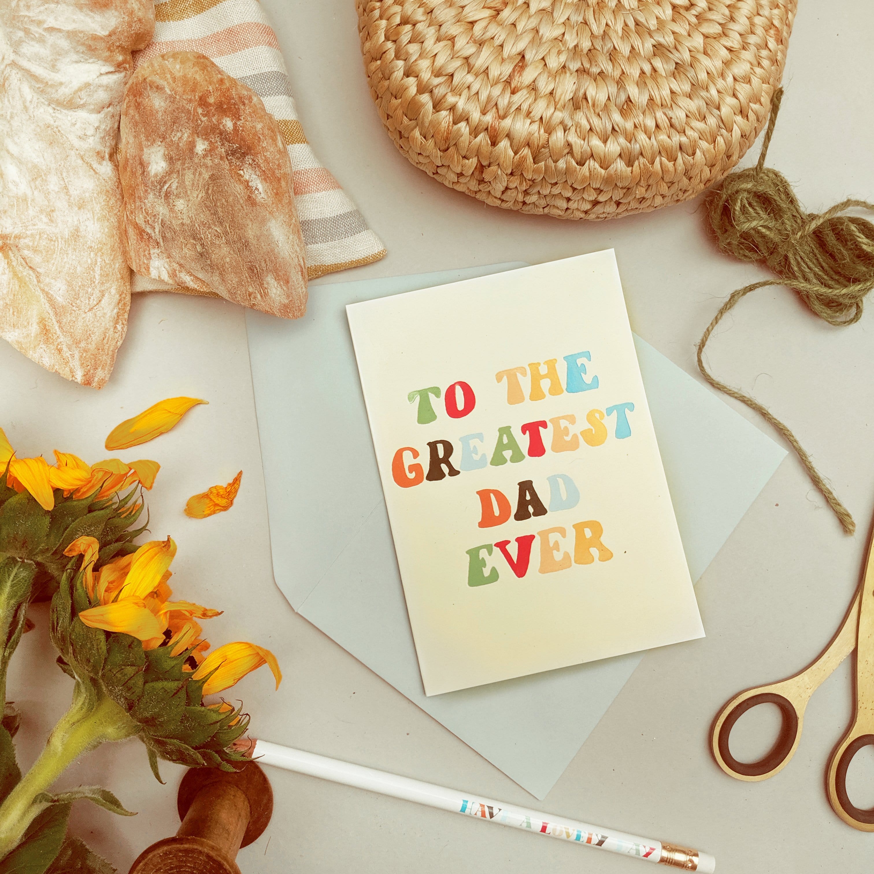 A Hand Lettered Rainbow Typography Father's Day Card Which Reads To the Greatest Dad Ever With Pale Grey Envelope On A Desk - Annie Dornan Smith