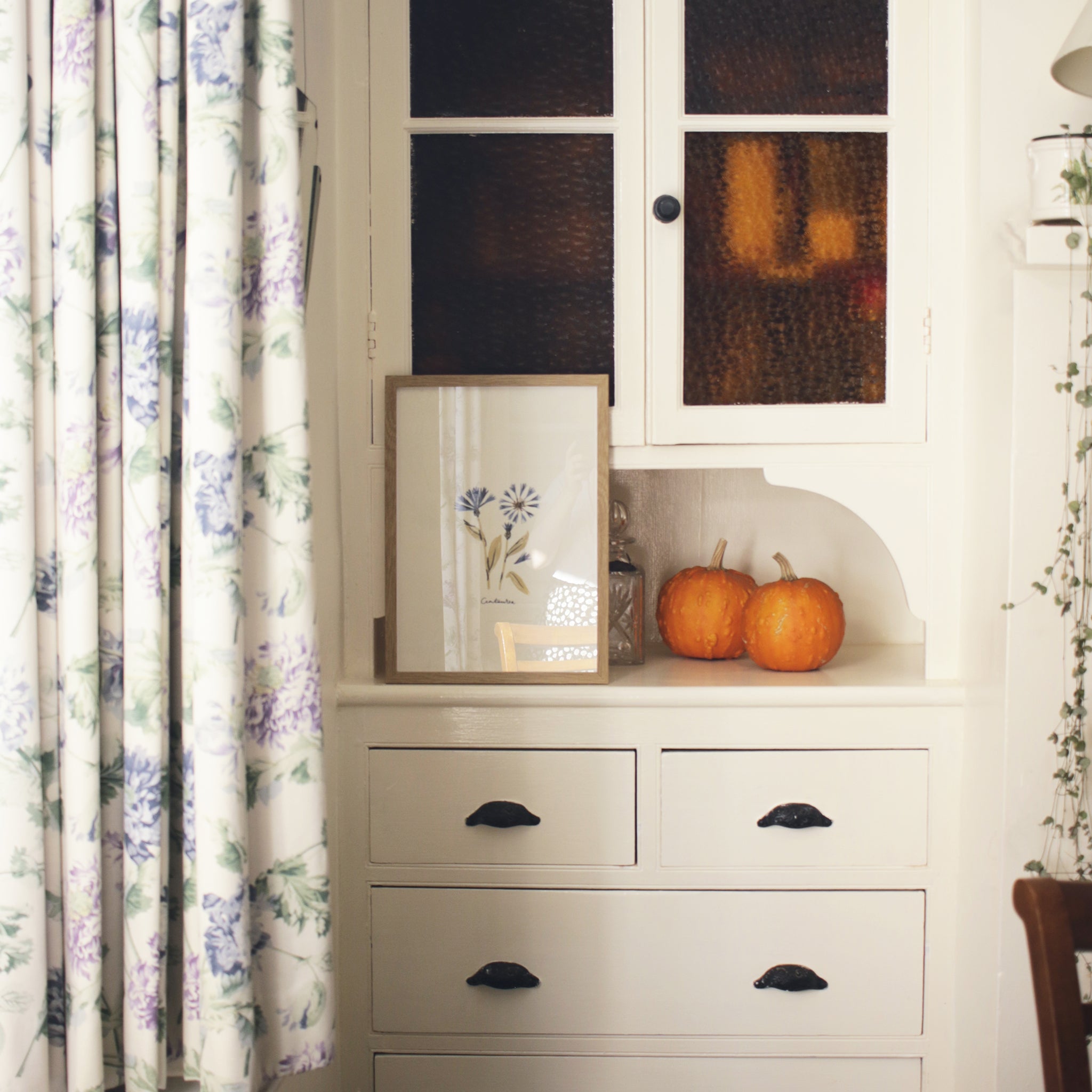 centaurea print propped on a vintage storecupboard