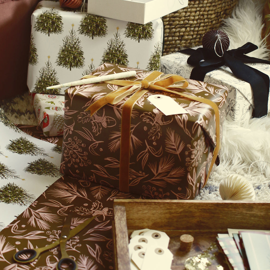 wrapping gifts in illustrated wrapping paper, under the tree