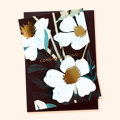 Illustrated White Flowers With Teal Leaves and Gold Centres On A Black Card With Congratulations In Gold With A Black Envelope - Annie Dornan Smith