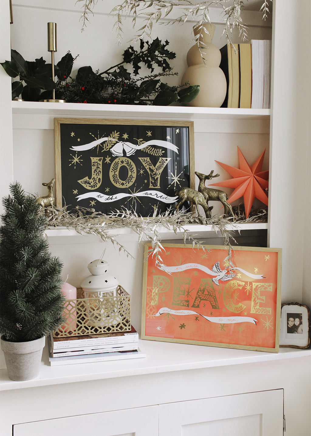 Navy Christmas Print With Gold Joy Lettering And Stars In An Oak Frame On A Book Shelf - Annie Dornan Smith
