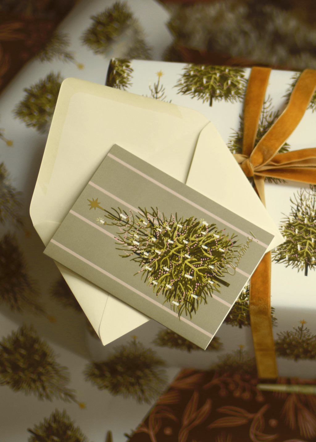 an illustrated christmas tree card with a cream envelope