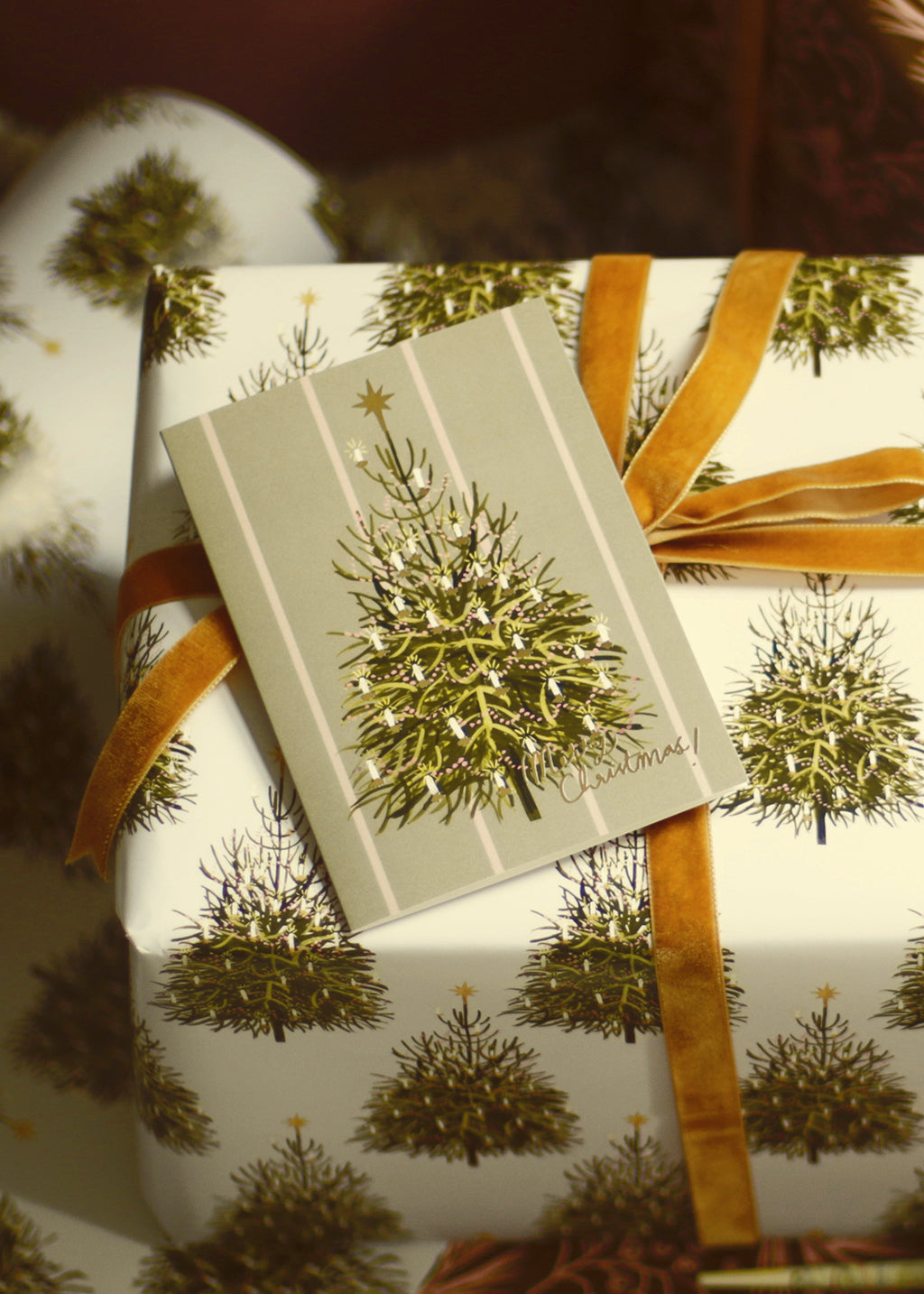 an illustrated christmas tree card with matching wrapping paper