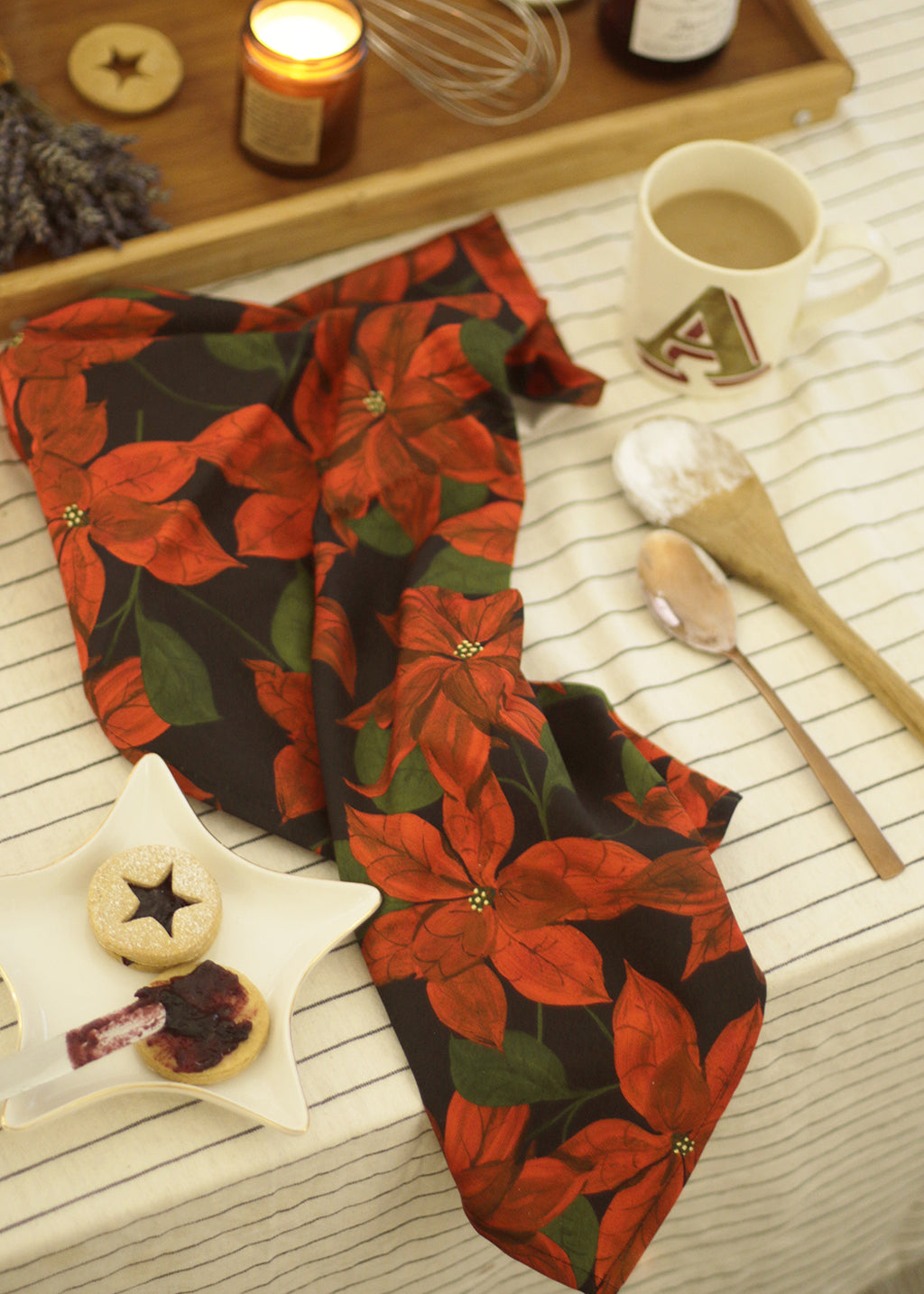 a cotton teatowel with a red poinsettia flower on black design.