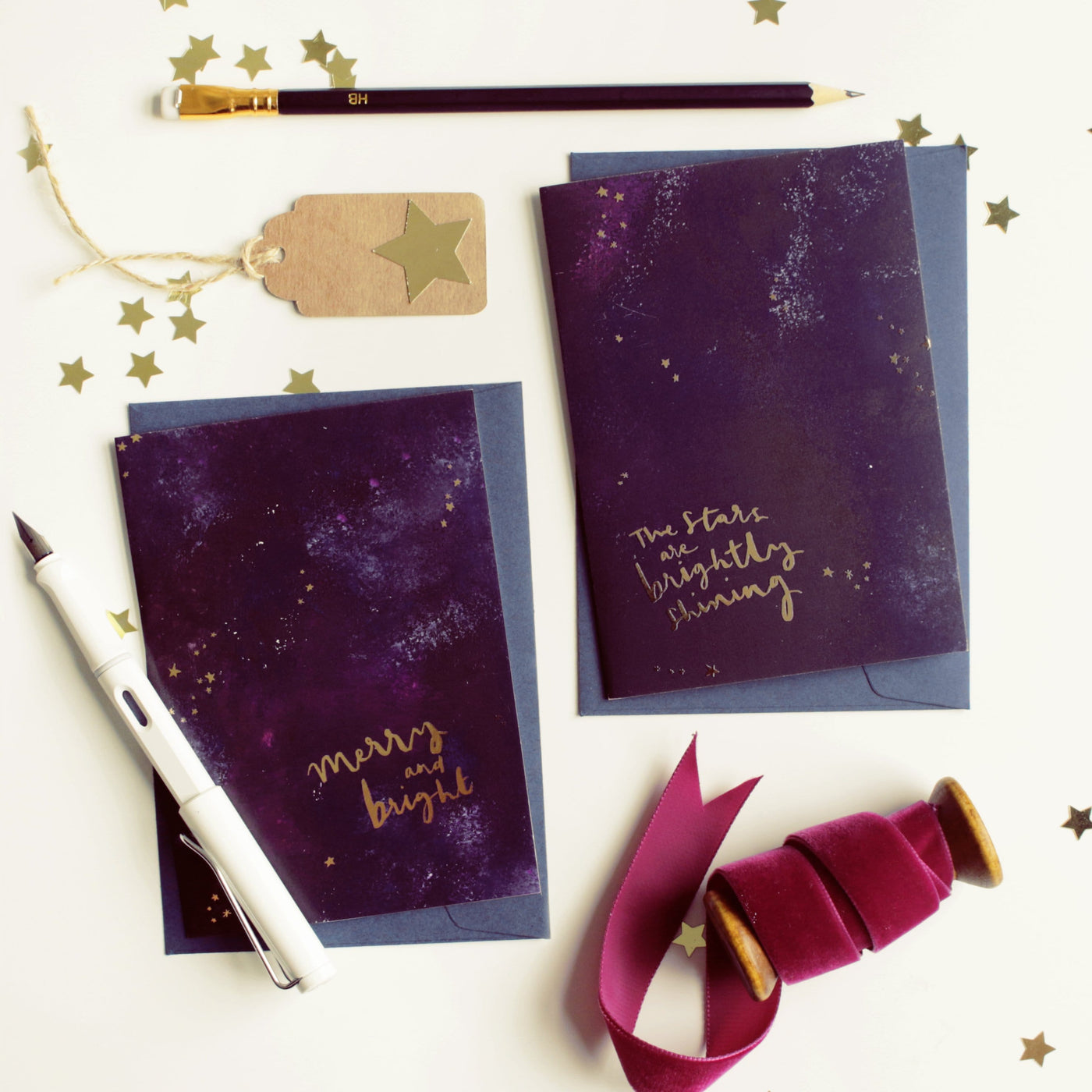 Purple Galaxy Christmas Card With The Words Merry An Bright In Gold With A Deep Navy Envelope With Another Galaxy Christmas Card - Annie Dornan Smith