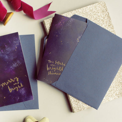 An Inky Galaxy A6 Card With The Stars Are Brightly Shining in Gold With A Blue Envelope - Annie Dornan Smith