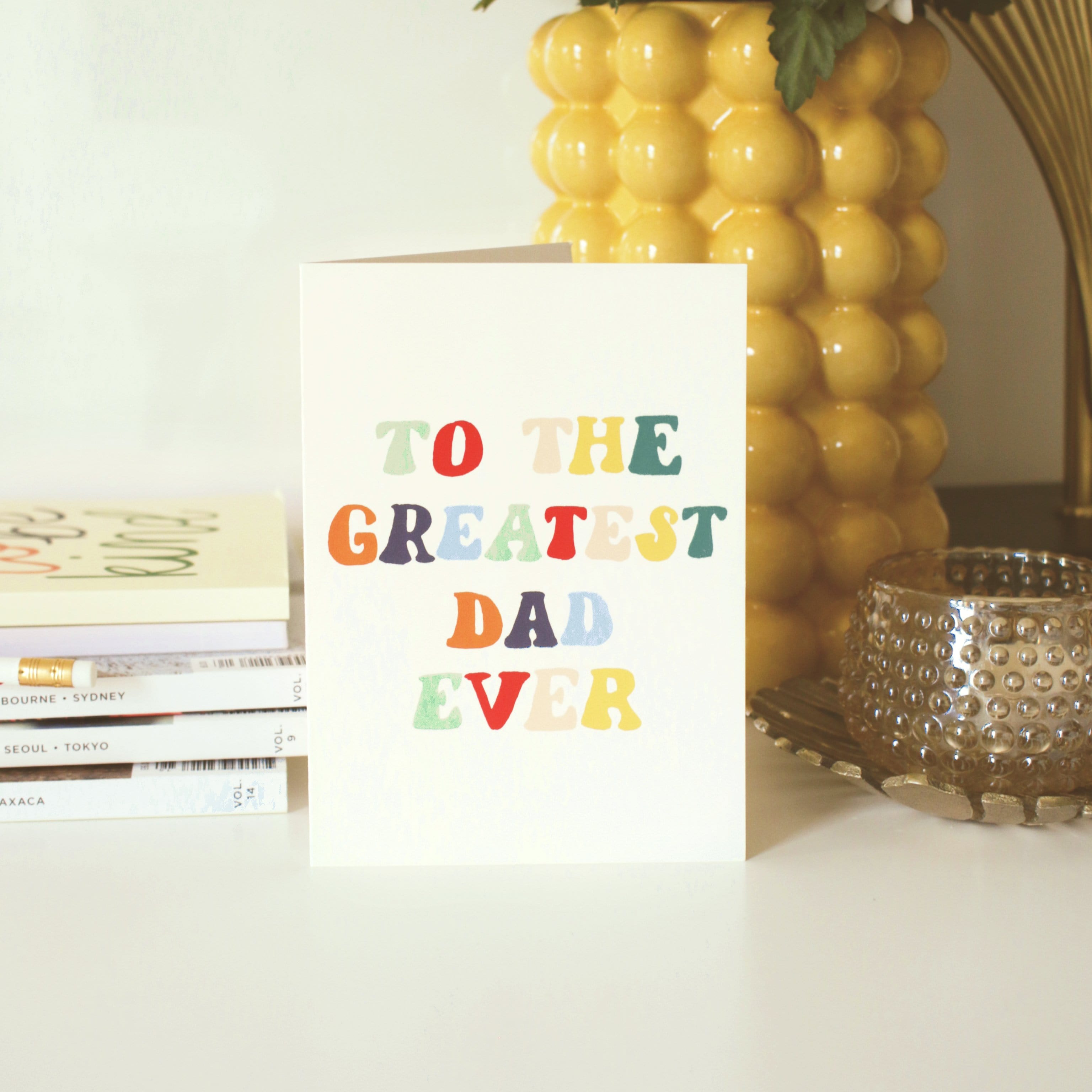 A Hand Lettered Rainbow Typography Father's Day Card Which Reads To the Greatest Dad Ever Next To A Pile Of Books - Annie Dornan Smith