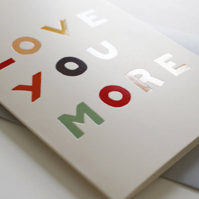 A Hand Lettered Rainbow Typography Card Reading Love You More With A Pale Grey Envelope - Annie Dornan Smith