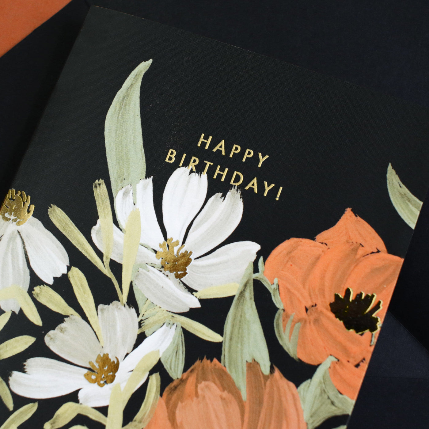 Illustrated Black Floral Card With White Orange And Blue Flowers And Gold Happy Birthday Lettering - Annie Dornan Smith