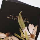 A Floral A6 Card With White And Green Flowers With Will You Be My Maid Of Honour In Gold Lettering  With Black Envelope - Annie Dornan Smith
