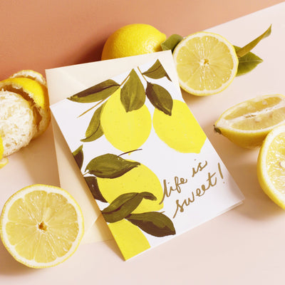 Illustrated Lemon and Green Leaf A6 Card With Life Is Sweet In Gold Lettering With Pale Yellow Envelope With Real Lemons - Annie Dornan Smith