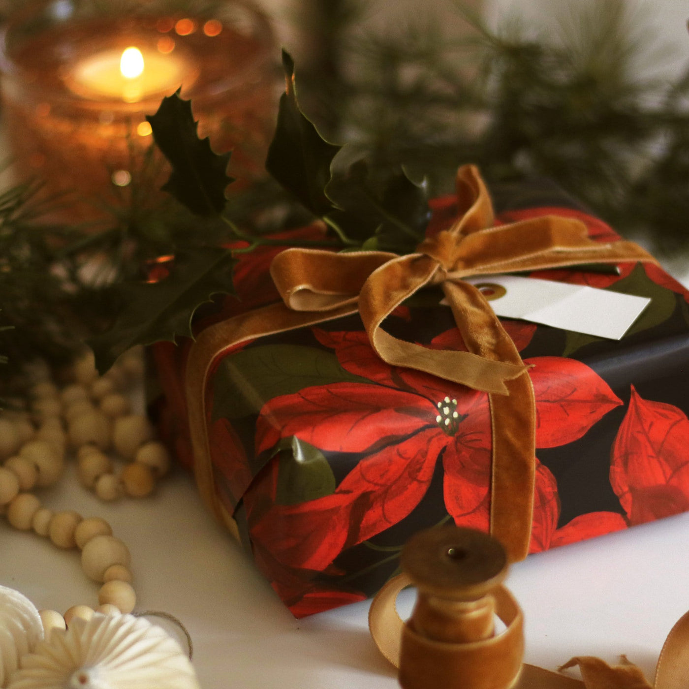 Gift Wrapped In Red Poinsettias Christmas Wrapping Paper With An Orange Velvet Ribbon Bow - Annie Dornan Smith