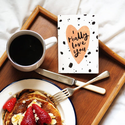 A Hand Lettered Card Which Reads I Really Love You On A Peach Heart With Black Paint Dots On A Breakfast Tray - Annie Dornan Smith