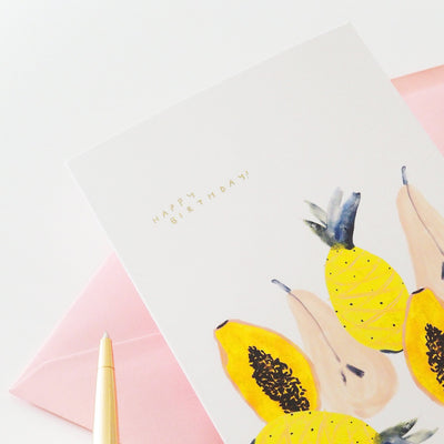 An Illustrated Tropical Fruit Card With Happy Birthday In Gold With A Pale Pink Envelope - Annie Dornan Smith