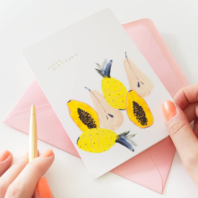 An Illustrated Tropical Fruit Card With Happy Birthday In Gold With A Pale Pink Envelope - Annie Dornan Smith