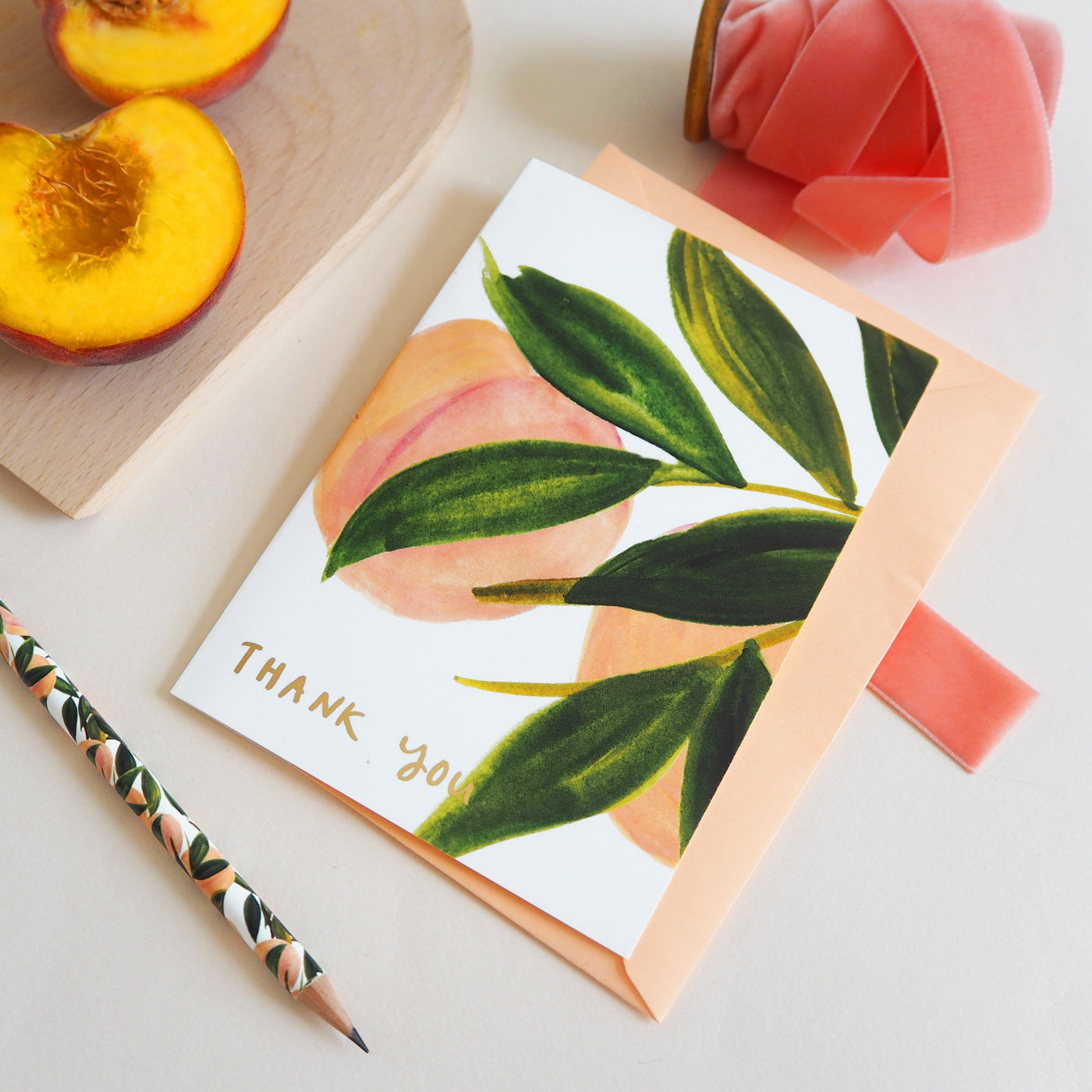 Illustrated Peach and Green Leaf Card With Thank You In Gold Lettering With Peach Envelope With Matching Pencil And Peach Halves - Annie Dornan Smith