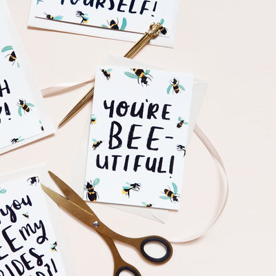 Hand Lettered Greeting Card Reading You're Beeutiful With A Gold Pen And Scissors - Annie Dornan Smith  Edit alt text