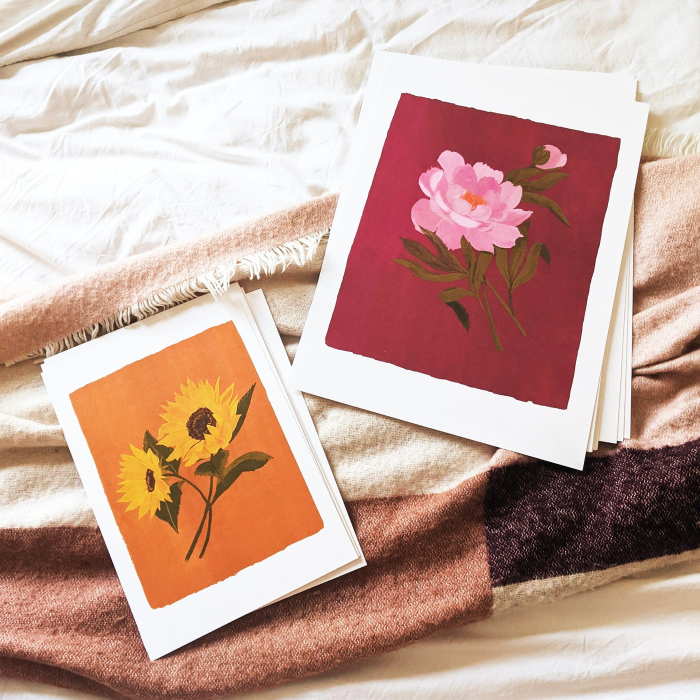 A Botanical Print Of A Pink Peony On A Burgundy Pink Background On A Blanket With A Sunflower Print - Annie Dornan Smith