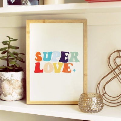 A Hand Lettered Rainbow Typography Print Which Reads Super Love In A Light Oak Frame On A Shelf - Annie Dornan Smith