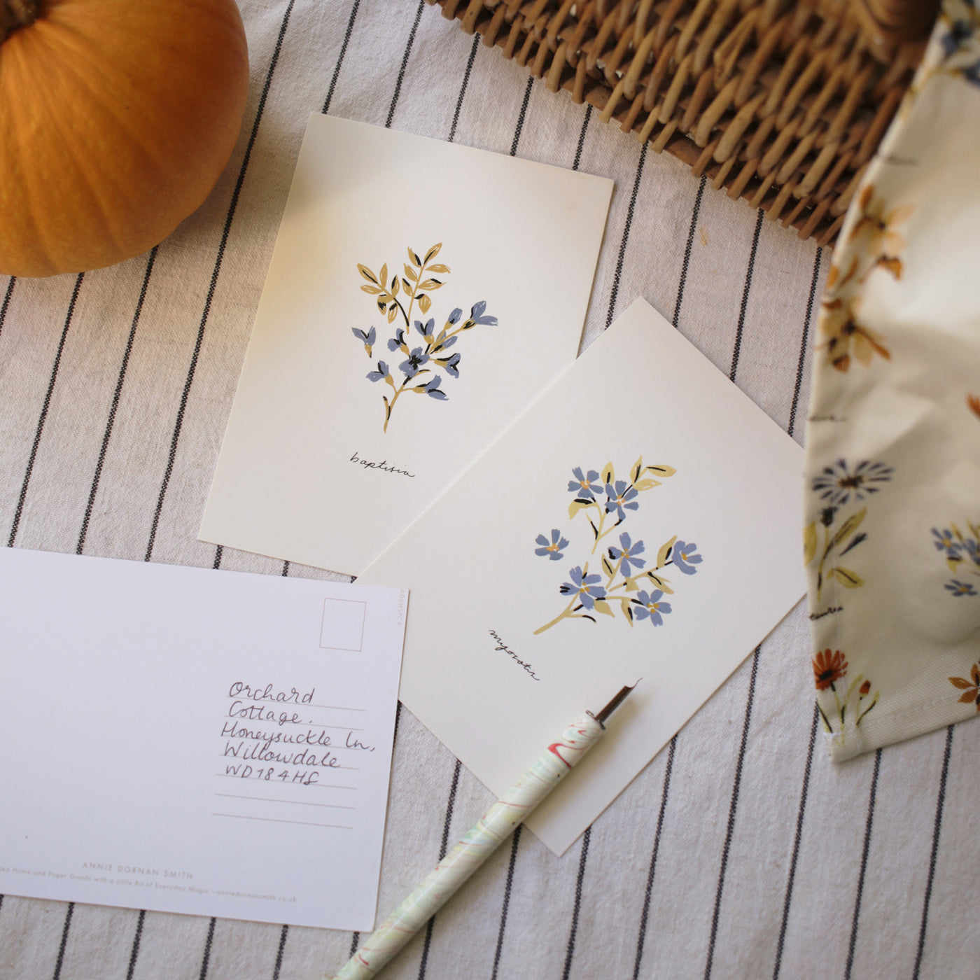 blue floral postcards on a striped linen tablecloth