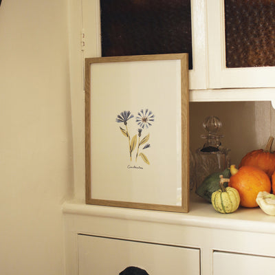 centaurea print in an oak frame, styled in an old wooden kitchen