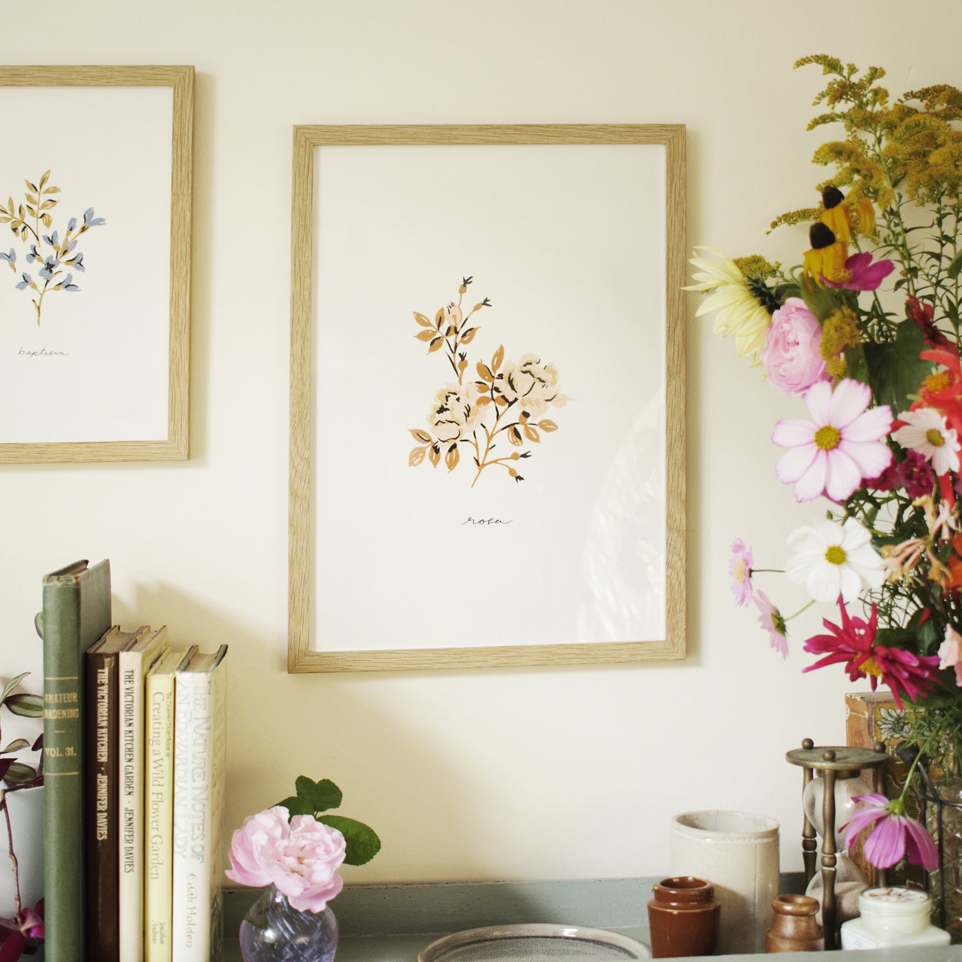 rose flower print hanging above a country style cabinet