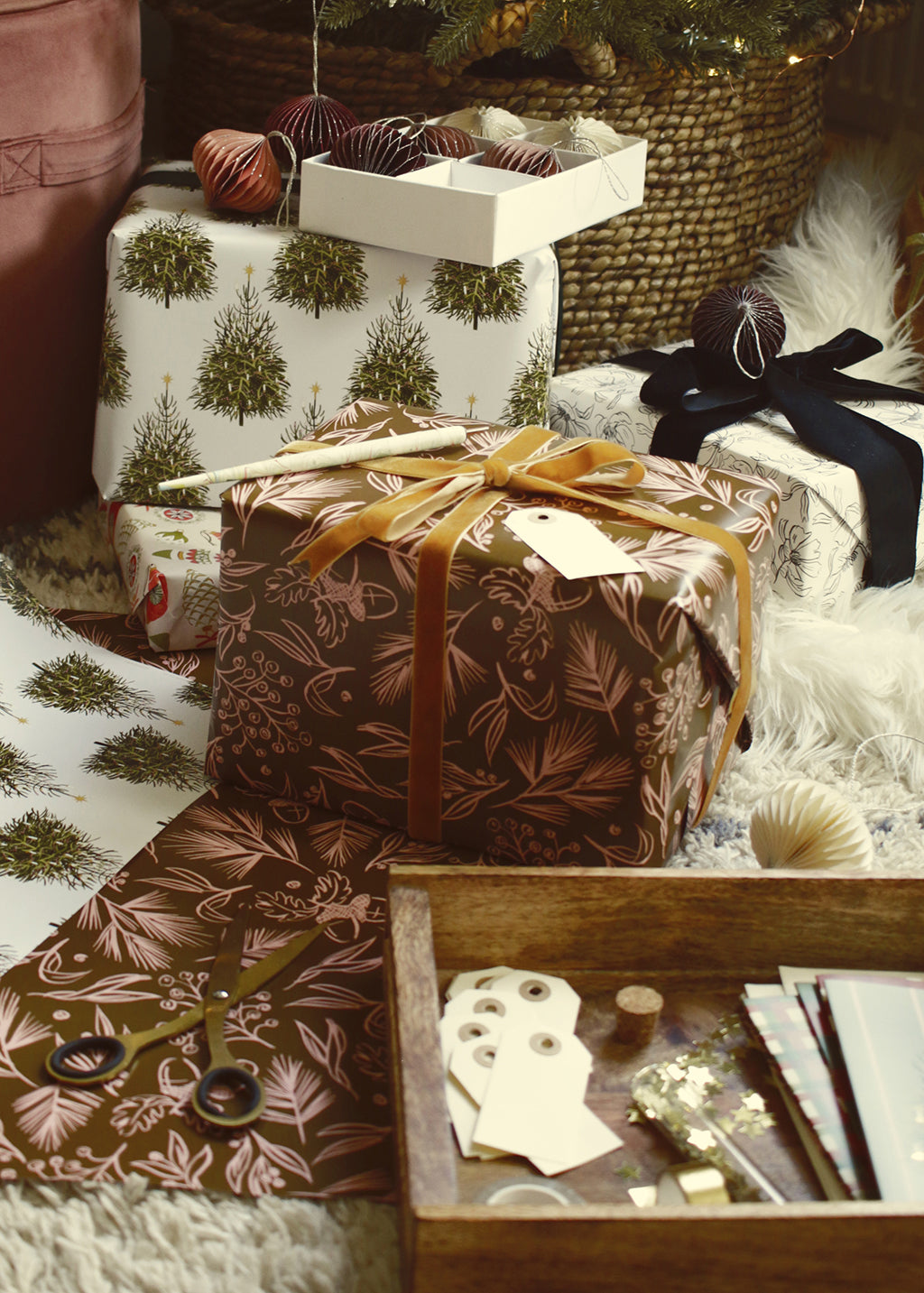 wrapping gifts in illustrated wrapping paper, under the tree