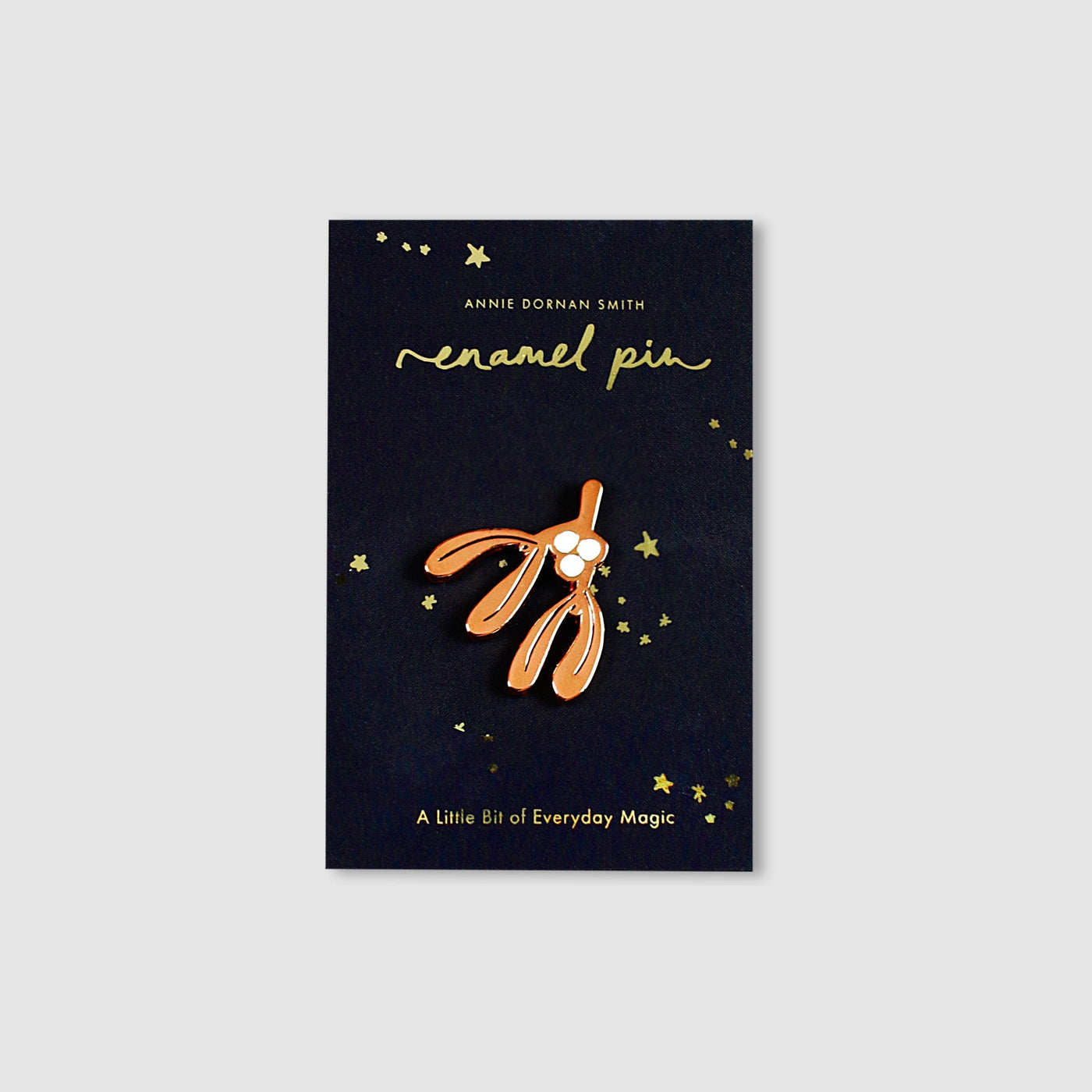Rose Gold Enamel Mistletoe Shaped Pin On A Black Backing Board - Annie Dornan Smith