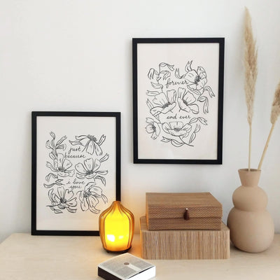 Two minimal floral prints hang in black frames - Annie Dornan Smith